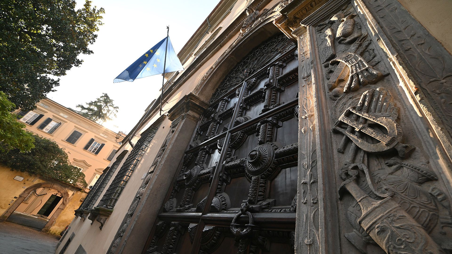 Portale di ingresso di Palazzo Orsetti, con portone in legno a cassettoni e cornice in pietra serena scolpita a bassorilievo con allegorie e figure della mitologia.
