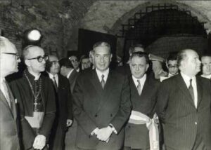 il senatore Aldo Moro e altre persone durante una mostra nei sotterranei delle Mura di Lucca