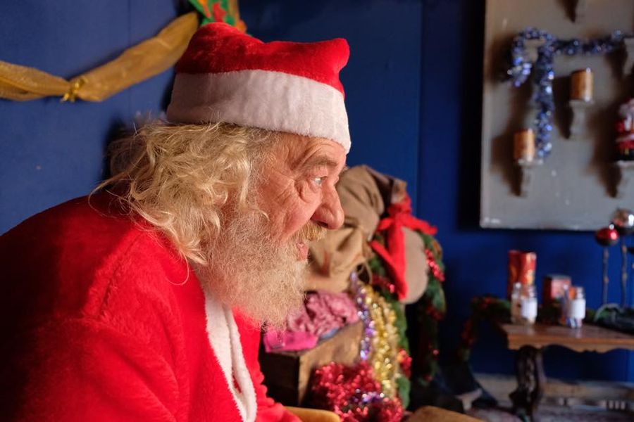 primo piano di babbo natale di profilo in una stanza con giocattoli
