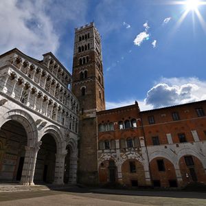 Cattedrale di San Martino dalla Piazza Antelminelli con il campanile e le case dell'opera del duomo in una giornata di sole.