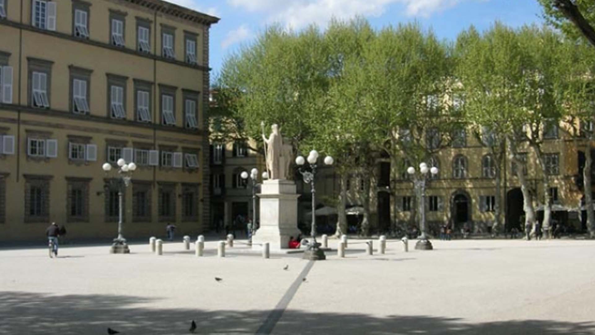 La statua di Maria Luisa di Borbone in piazza Napoleone. Sul fondo la facciata di Palazzo Ducale e gli alberi che circondano la Piazza