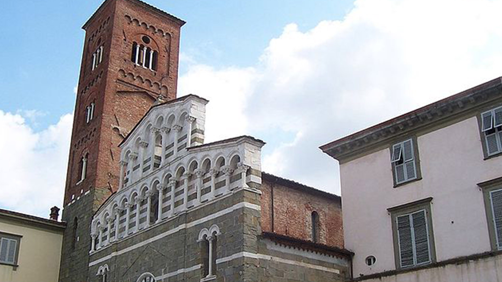 particolare della Chiesa di San Pietro Somaldi con il campanile. La fascciata della chiesa, in pietra serena, chiesa ha copertura a falde. Nella parte alta due file di loggette sovrapposte in marmo. Il campanile è di mattoni con un disegno di riqadria in cui si aprono finestre a polifora e loggia campanaria coperta.