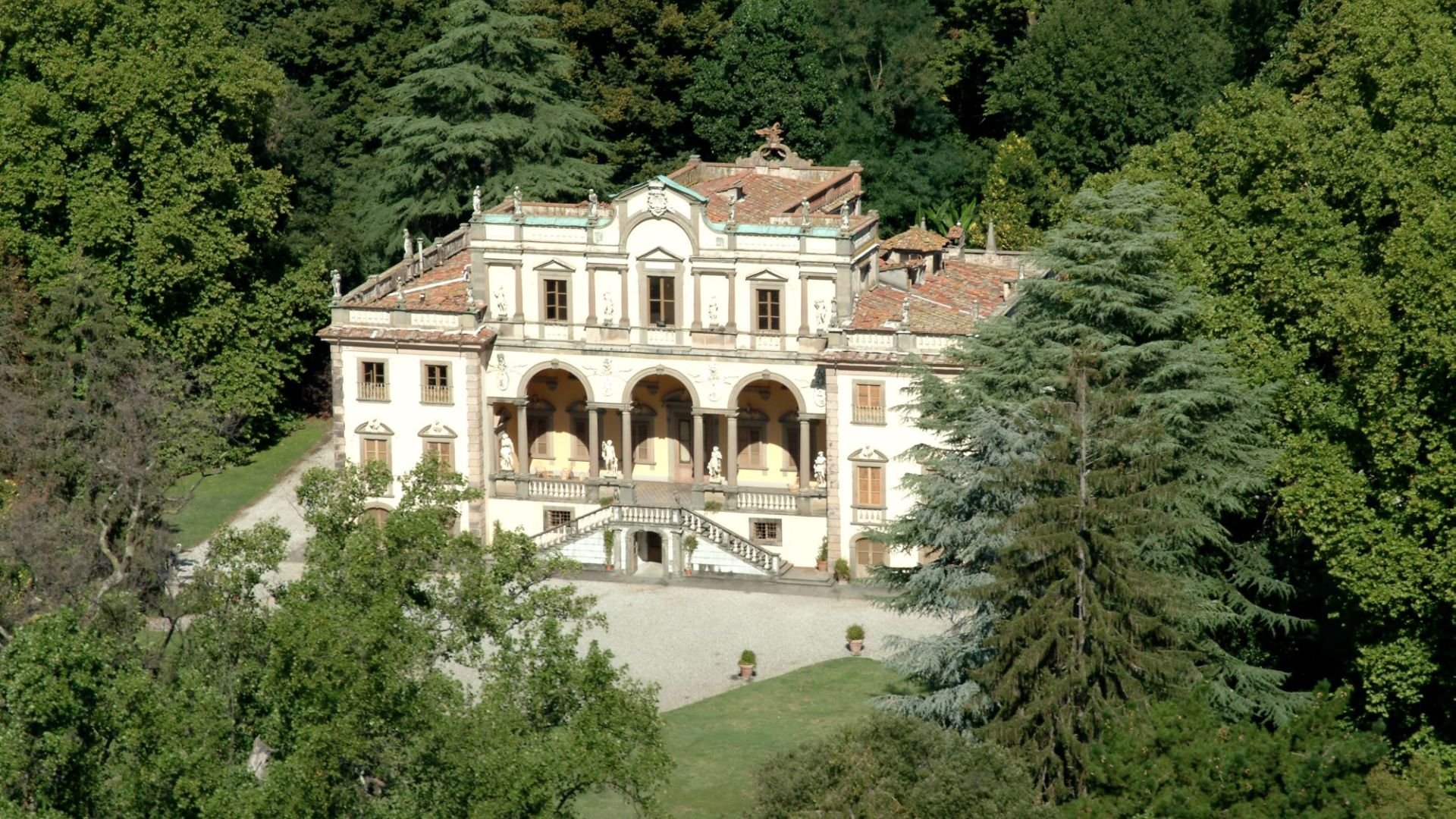 Vila Mansi immersa nel verde del suo parco. La villa è in stile neoclassico con scala a doppia rampa che accede al loggiato a serliana del piano nobile.