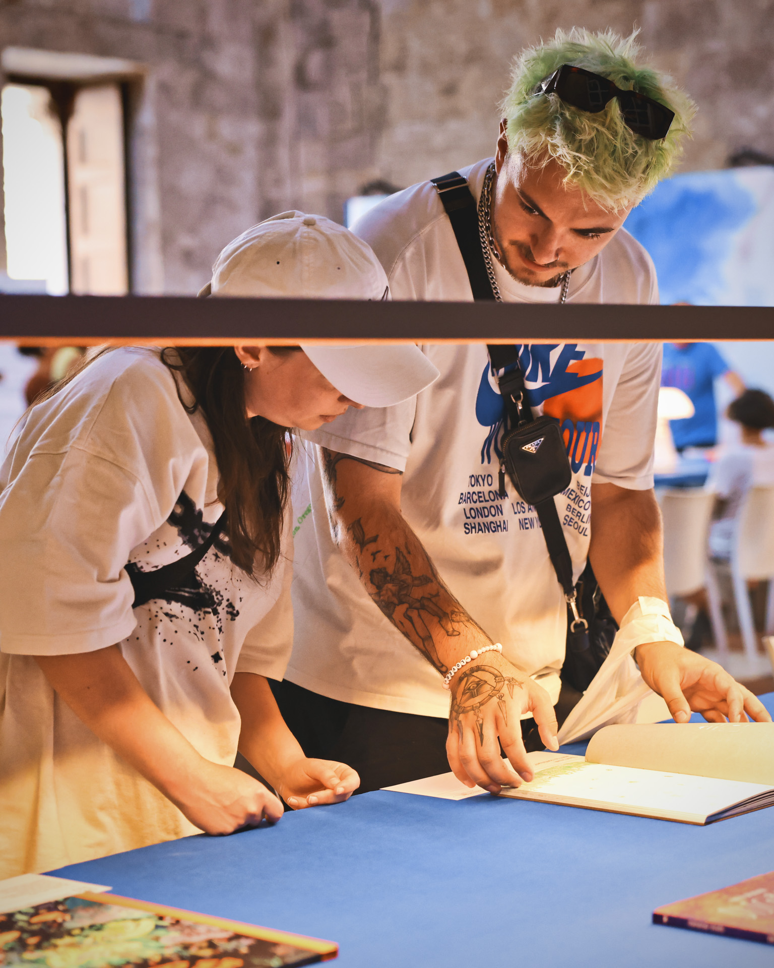 Due persone a immagina festival sfogliano dei libri appoggiati su un tavolo