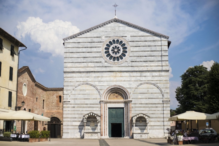 La facciata della chesa di San Fracesco è molto lineare con profilo a capanna e decorazione a fasce alterne di marmo bianco e verde. Nella parte bassa tre grandi archi ciechi con due arche. Nella parte alta c'è un rosone.