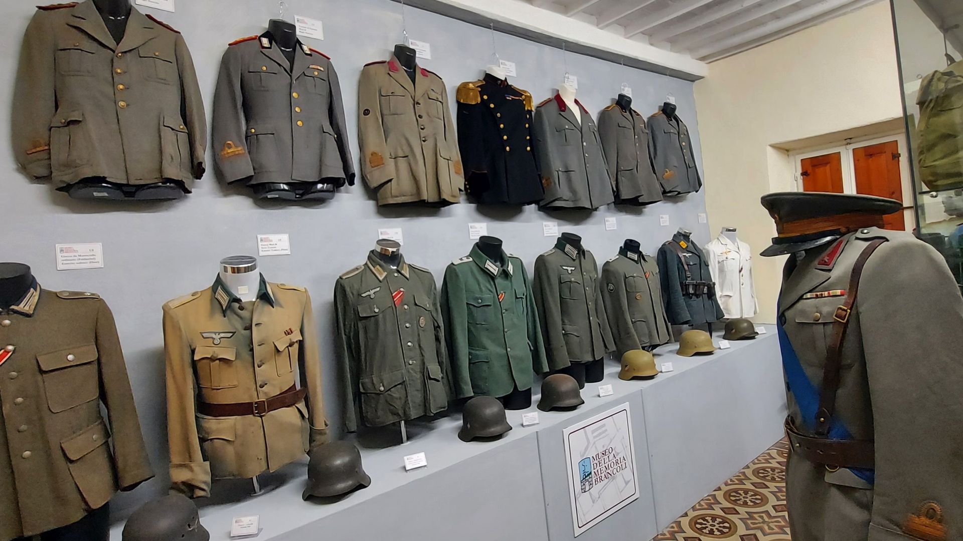 Sala Tedesca e Italiana del Museo della Memoria di Bracoli15 uniformi appese ad una parete e un manichino con uniforme con stellette. Ai piedi delle uniformi ci sono 7 elemtti.