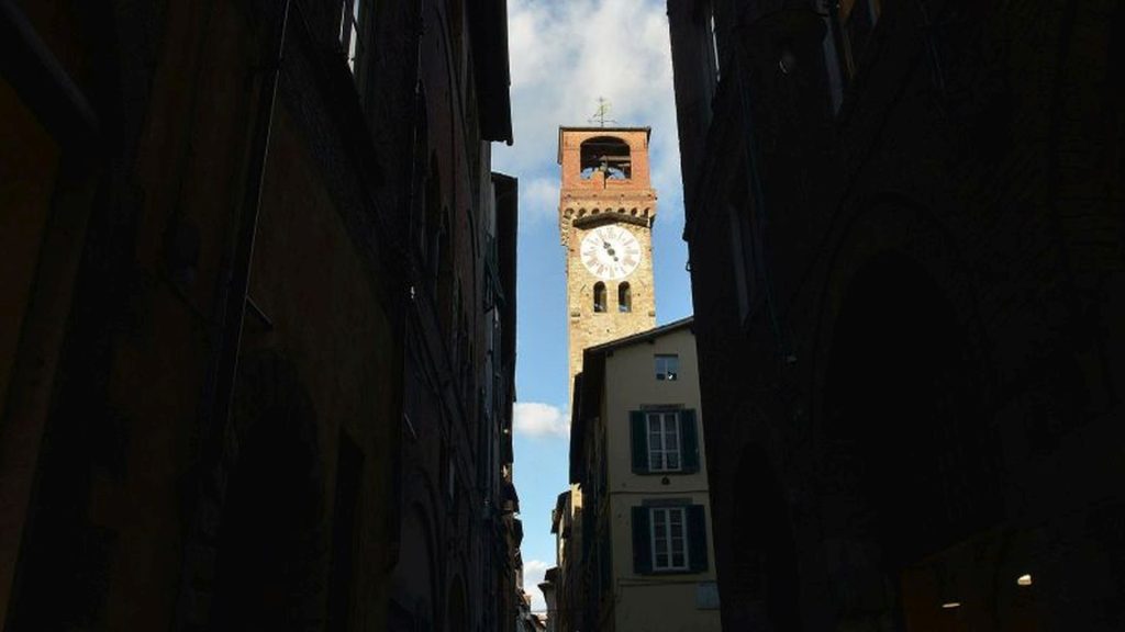 Dal canto d'Arco (incrocio di via Fillungo con via Roma), tra gli alti edifici, uno spicchio di cielo azzurro con la Torre delle Ore. Sulla torre, il quadrante del grande orologio settecentesco e in cima la cella campanaria copertoa e la banderuola che reca la scritta libertas