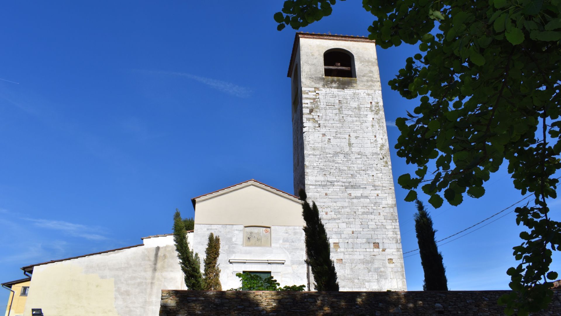 la faccaita della chiesa di Santo Stefano Protomartire di Pozzuolo con il campanile in pietra calcarea