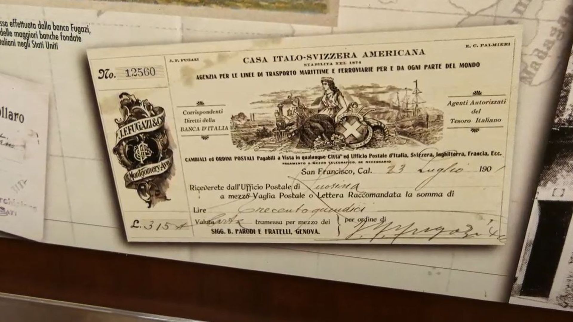 cambiale del 1900 in carta ingiallita con il disegno di una donna che simoboleggia lìItalia con uno scudo della svizzera si suoi piedi e ai lati un treno e una nave e la scritta: casa Italo-svizzera americana stabilita nel 1876- Agenzia per le linee di trasporto marittime e ferroviarie per e da ogni aprte del mondo. Corispondenti diretti della Banca d'Italia. Agenti autorizzati del tesoro italiano.. Cambiali e ordini postali pagabili a vista in qualunque città ed ufficio postale d'italia, svizzera, inghilterra, francia, ecc. San Francisco 23 luglio 1900 riceverete dall'ufficio psotale di Ruosina a mezzo valgia postale o lettera raccomandata la somma di Lire trecentoquindici.