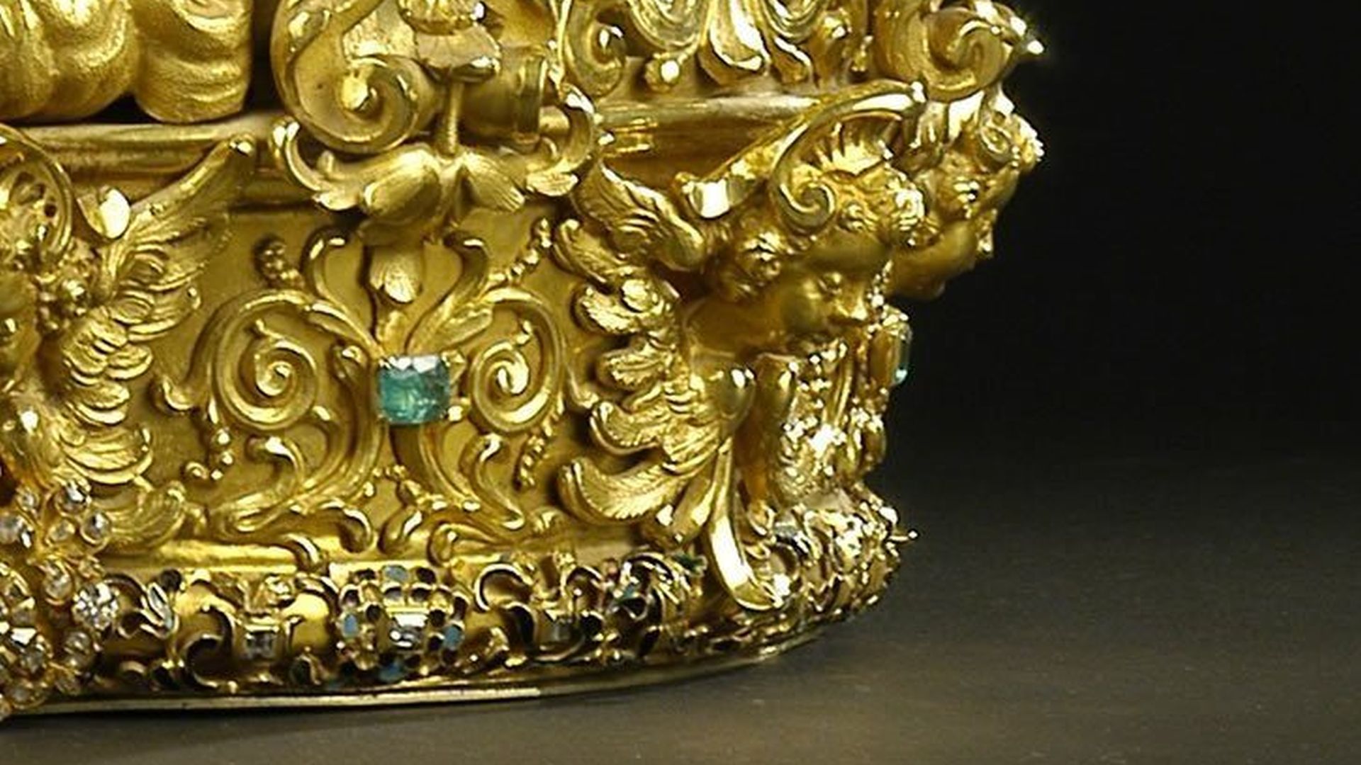 Particolare della corona del Volto Santo con lavorazione e figure di angeli e volute e uno smeraldo incastonato