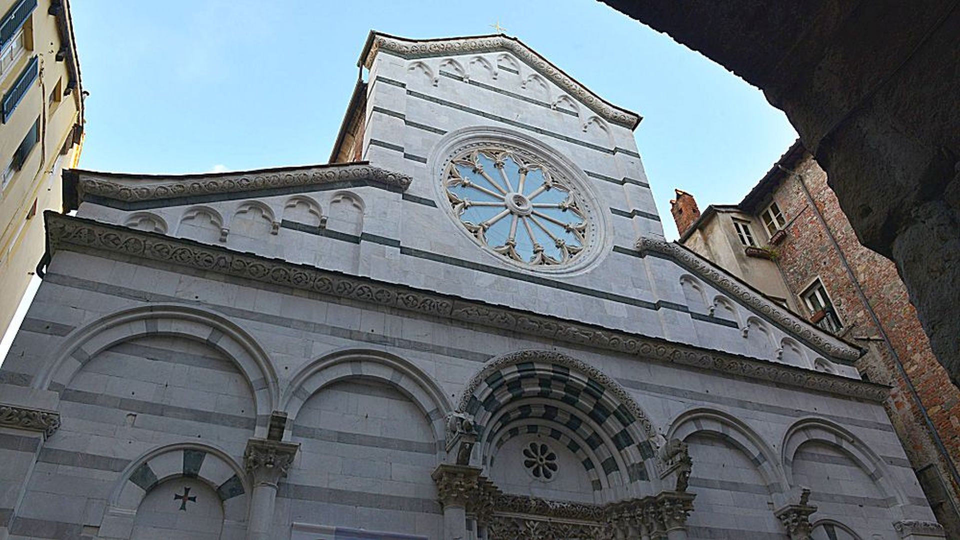La chesa di San Cristoforo in via Fillungo ha una facciata romanica in marmo bianco e verde e un grande rosone nella parte alta.