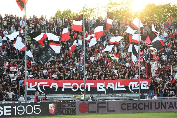 tifosi della lucchese allo stadio con bandiere euno striscione con il testo: lucca football club