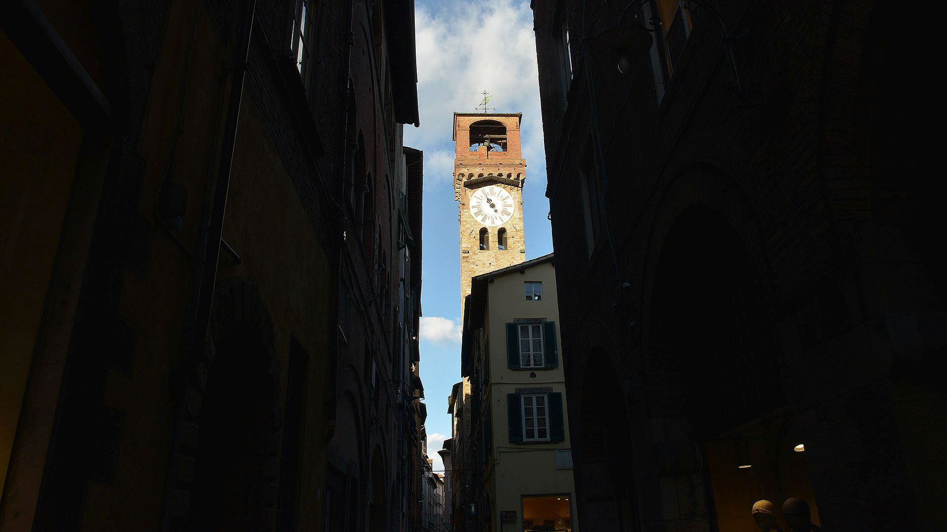 Dal canto d'Arco (incrocio di via Fillungo con via Roma), tra gli alti edifici, uno spicchio di cielo azzurro con la Torre delle Ore. Sulla torre, il quadrante del grande orologio settecentesco e in cima la cella campanaria copertoa e la banderuola che reca la scritta libertas