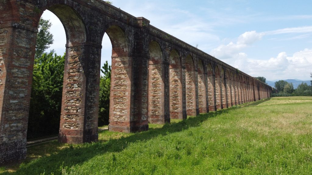 Prospettiva delle arcate dell'acquedotto del Nottolini nella campagna lucchese in primavera