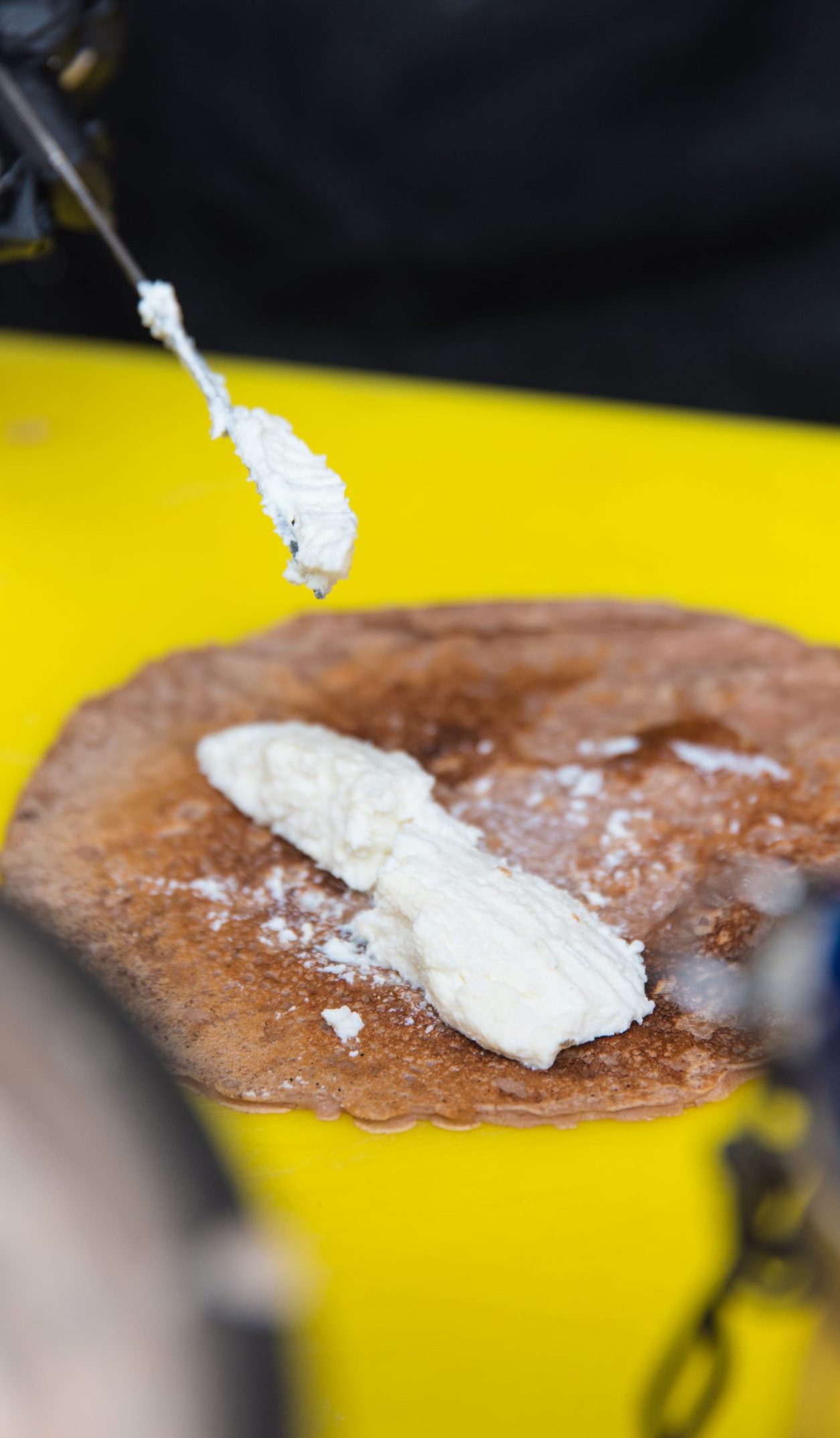 Una frittella di farina di castagne su cui è spalmata della ricotta
