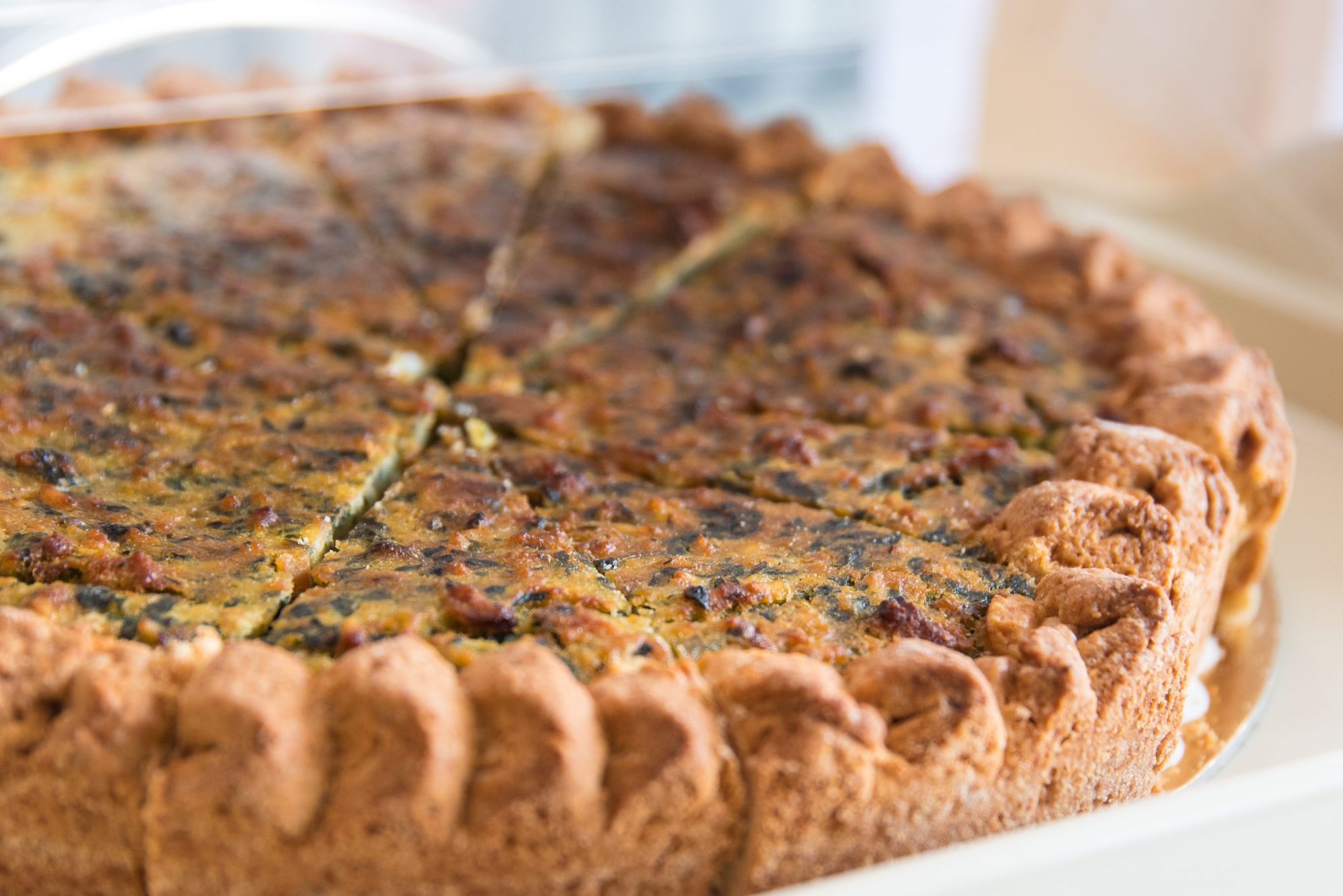 primo piano della caratteriscica torta di erbi lucchese con piccoli riccioli di pastra frolla intorno