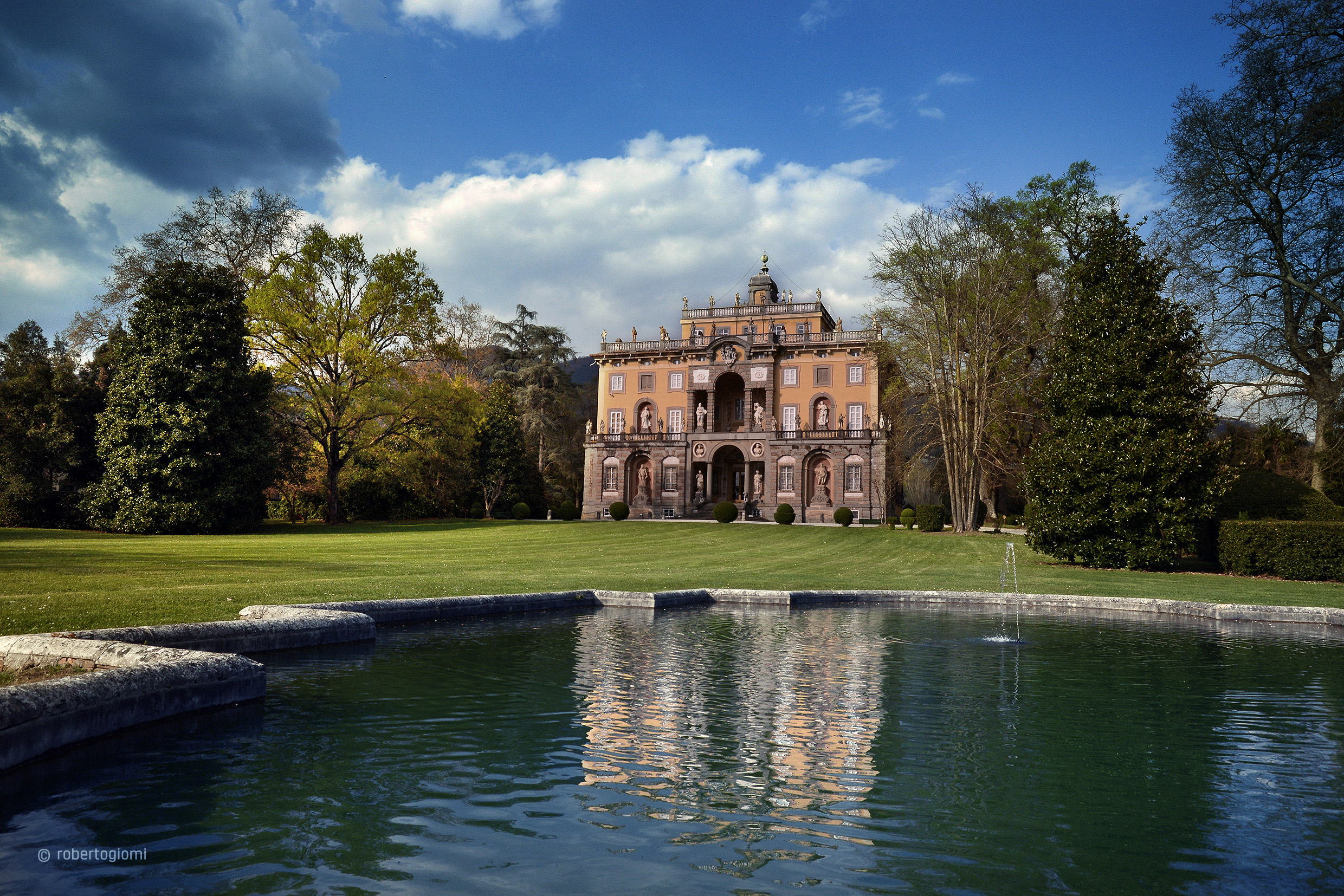 Circondata da alti alberi, vegetazione, la facciata barocca di Villa Torrigiani di Camigliano si specchia nella fontana del prato. Al piano terra il bugnato incornicia edicoledove sono poste delle statue. Il piano nobile e quello superiore sono intonacate e nel centro si apre una loggia con moivo di finestra a serliana. Sulla sommità un belvedere cintato da una balconata e statue.