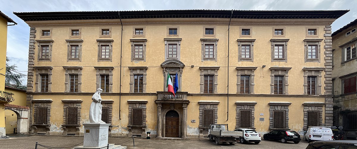 Facciata del palazzo Guidiccioni. tre piani con oto grandi finetre per piano a un ingresso centrale sormontato da un terrazzino. Sulla piazza la statua del musicista Gemignani