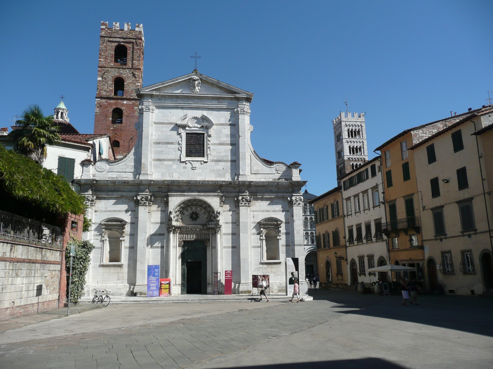 chiesa di San Giovanni e Santa Reparata a Lucca in sitle seicentesco divisa verticalmente con lesene. Dietro la chiesa il campanile e la cupola del battistero.Sullo sfondo la cattedrale di San Martino con il campanile