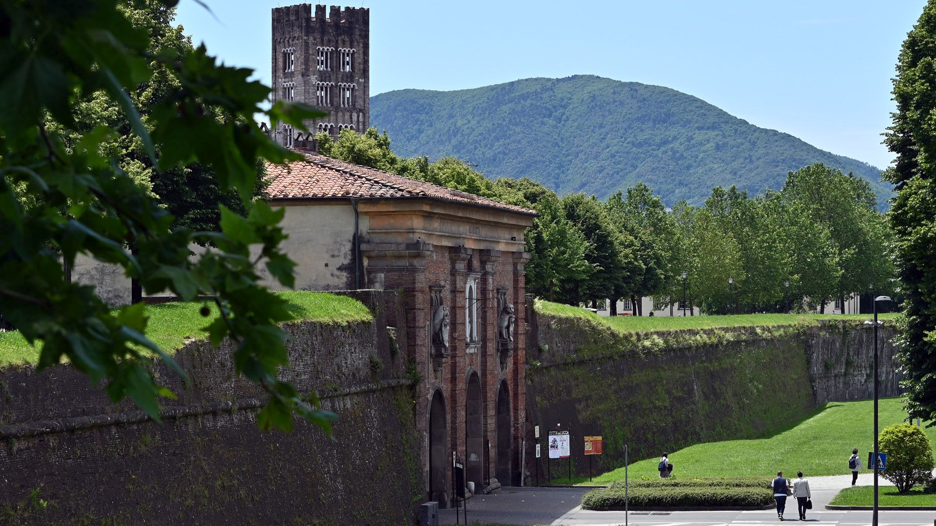 scorcio delle Mura di Lucca con Porta Santa maria e il campanile della basilica di San Frediano. Sullo sfondo il Monte Pisano.