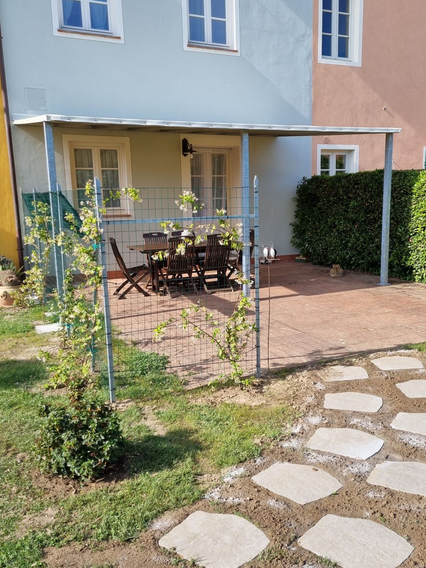 ingresso del bb le rondini, un piccolo patio ombreggiato con un tavolo da pranzo in un giardino