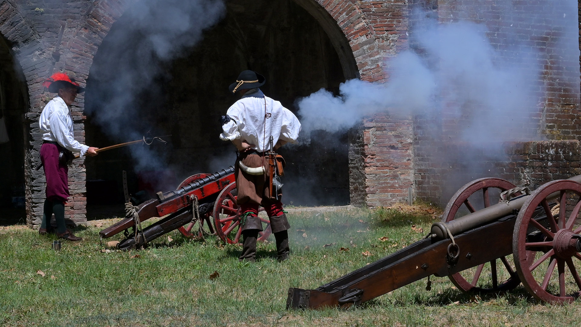 due figurati in abiti seicenteschi sparano con un cannone sulle mura di lucca