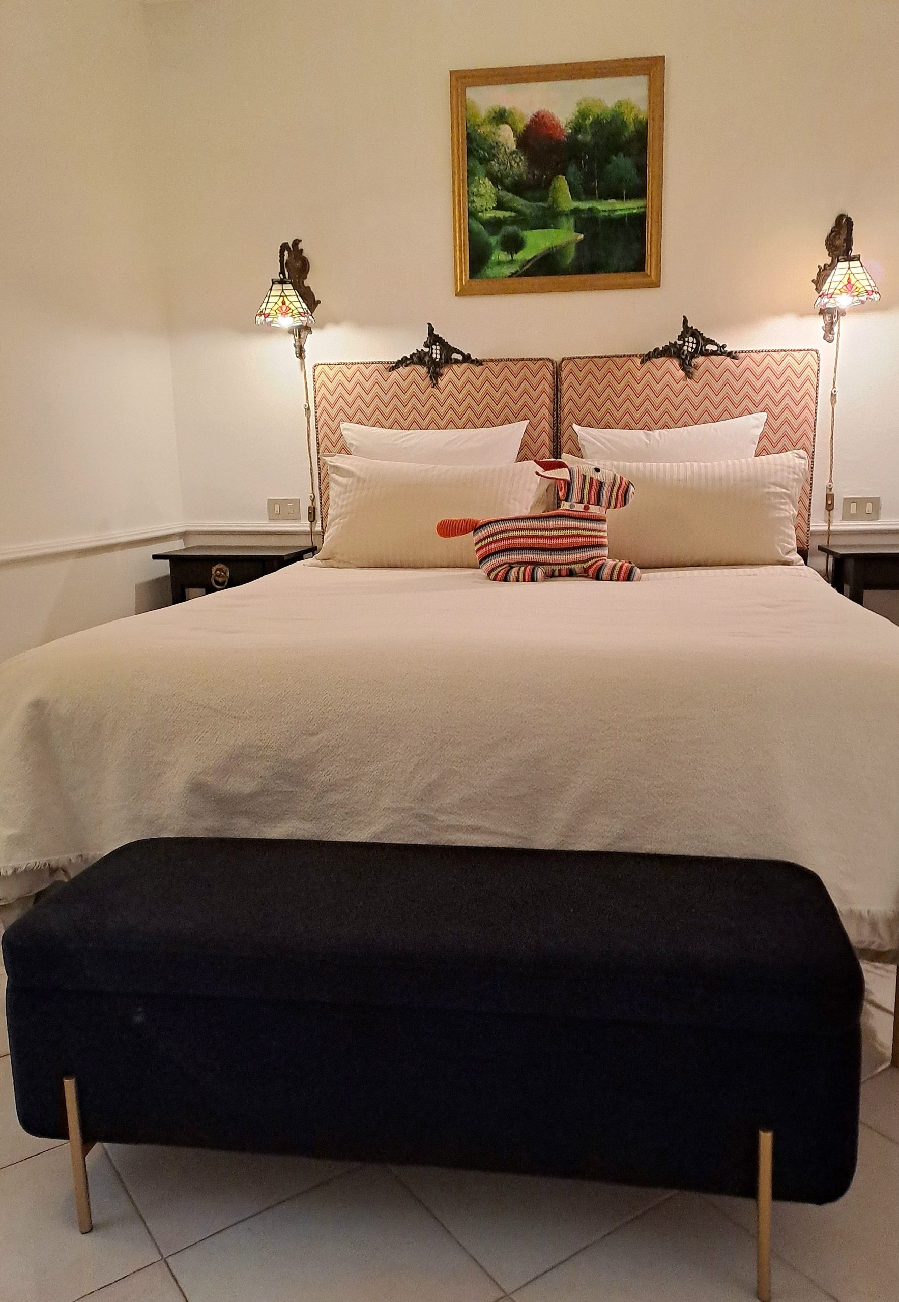 La camera da letto della casa vacanze serenità san martino ha luci soffuse.