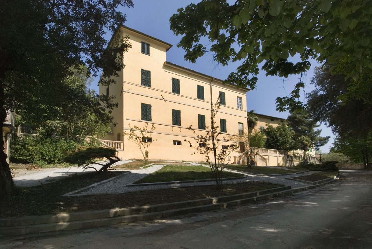 facciata dell'ex ospedale psichiatrico di maggiano tra la vegetazione